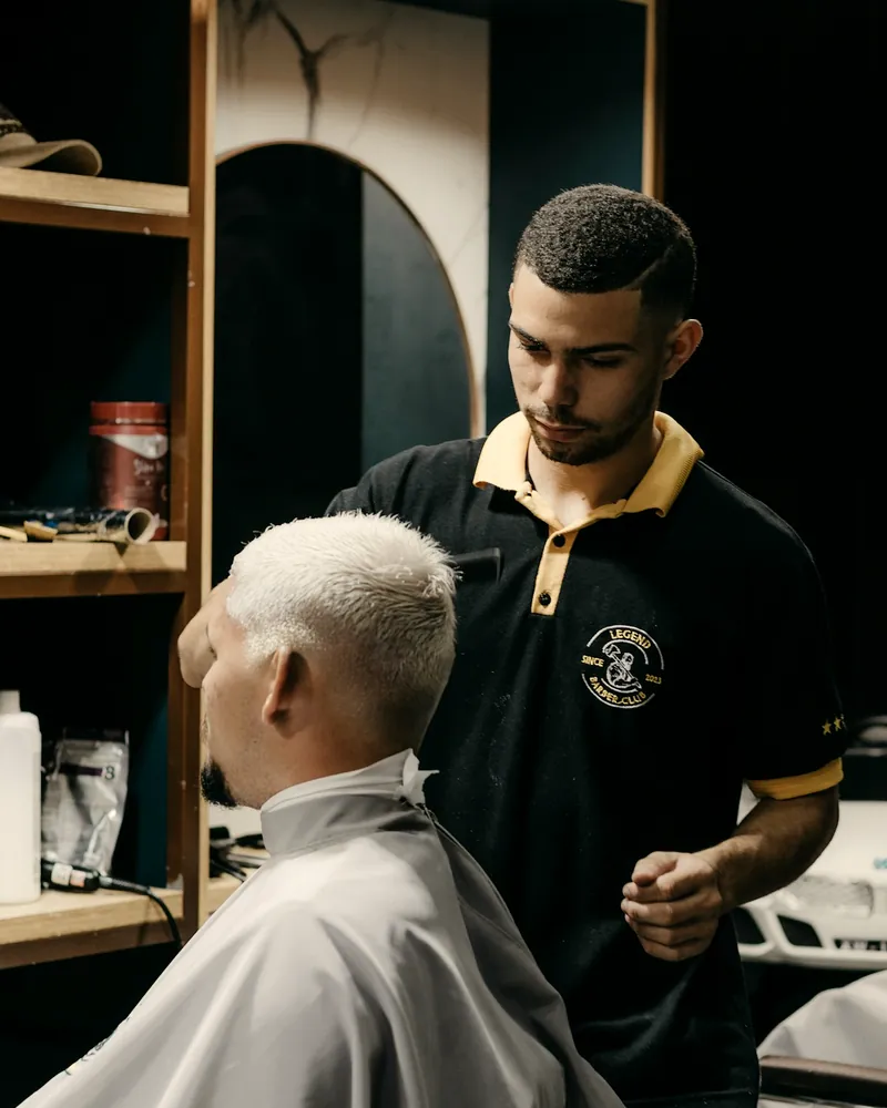 Barbero repasando el corte de un cliente de pelo blanco